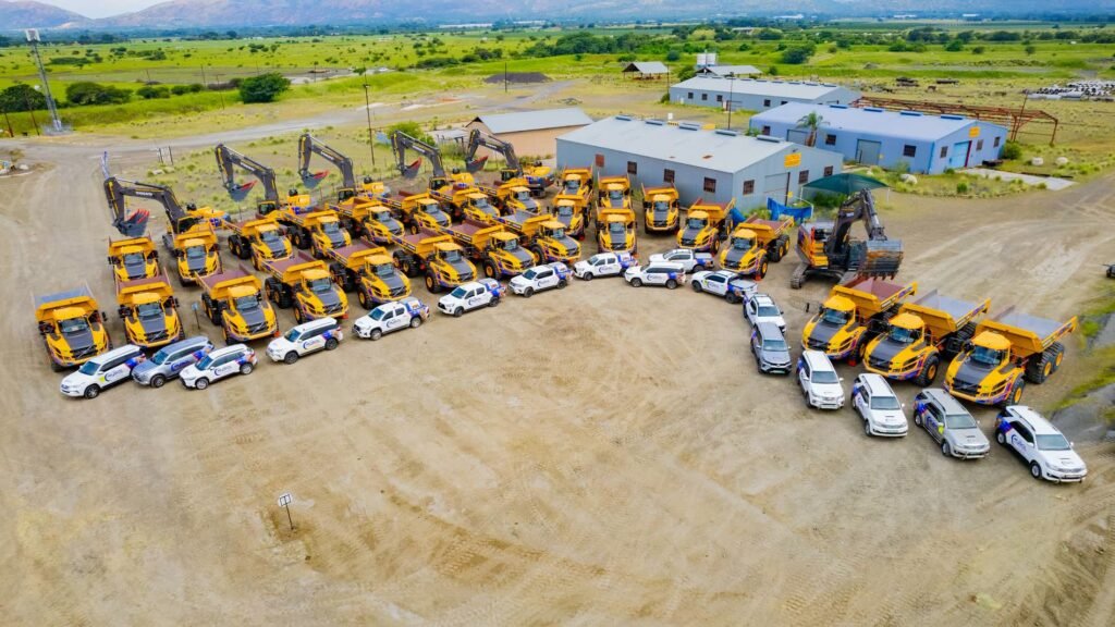 Aerial view of MySol yellow haul trucks, excavators and company vehicles lined up at a mine site